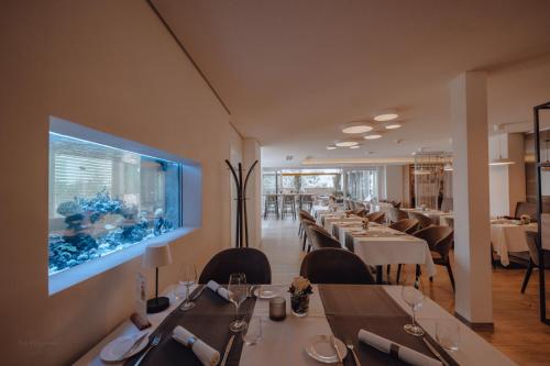 a restaurant with tables and a fish tank on the wall at Hotel-Restaurant Römerhof Superior in Herrenberg