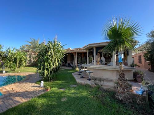 a house with a palm tree in the yard at Authentic Villa Ideal for 16+ guests in Marrakesh