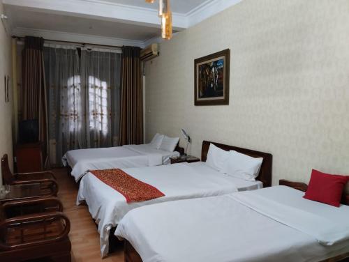 a hotel room with three beds and a window at Holiday home in Hanoi