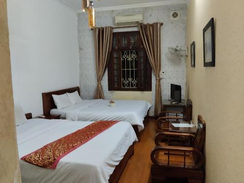 a hotel room with two beds and a window at Holiday home in Hanoi
