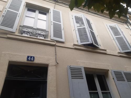 un bâtiment avec des fenêtres blanches à volets et un certain nombre de dans l'établissement Appartement en centre ville, à Nevers