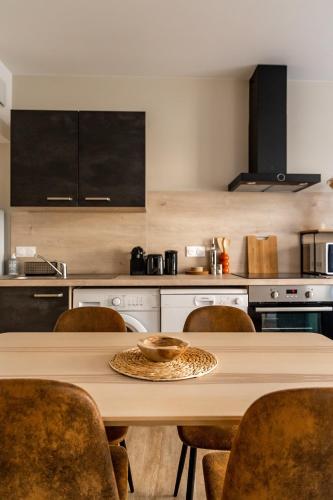 une cuisine avec une table et des chaises en bois dans l'établissement Zélia - 2 chambres - Dinan centre historique, à Dinan