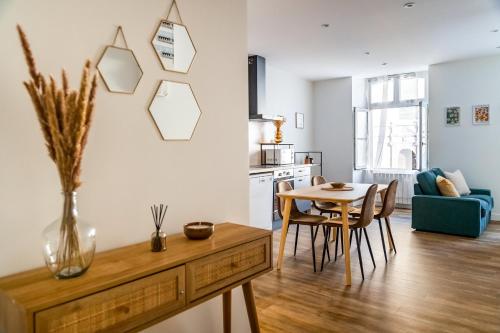 Il comprend un salon avec une table et une cuisine avec une salle à manger. dans l'établissement Zélia - 2 chambres - Dinan centre historique, à Dinan