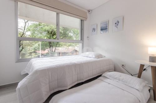 1 dormitorio blanco con 2 camas y ventana en Luxurious House With Two Bedrooms Magnificent Views Villa Morra, en Asunción