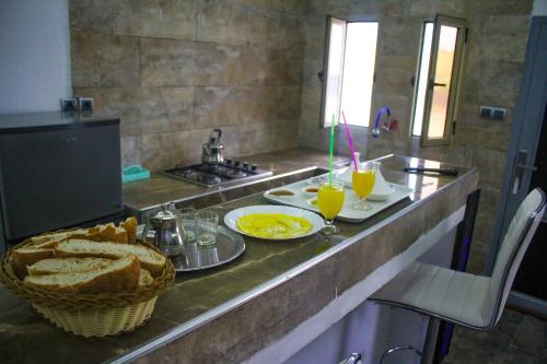 a kitchen with a counter with bread and two glasses of orange juice at Equinox in Tan-Tan Plage