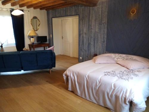 um quarto com uma cama e um sofá azul em Ferme de la NOE 