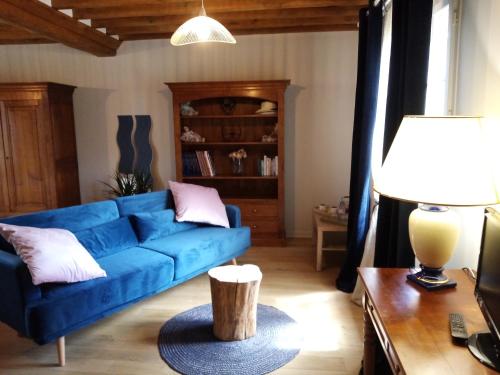 a living room with a blue couch and a table at Ferme de la NOE in Sérigny