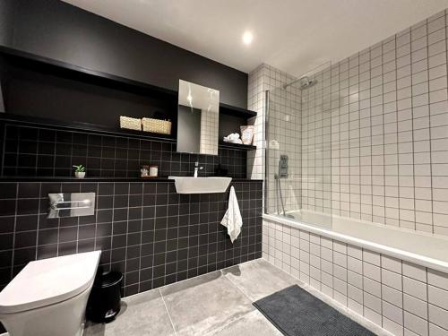 倫敦的住宿－Glitz and Luxury，浴室配有卫生间、盥洗盆和浴缸。