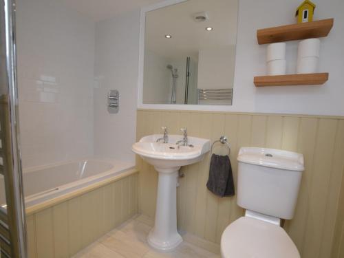 a bathroom with a sink and a toilet and a bath tub at 3 Bed in Burton Bradstock DC055 in Burton Bradstock