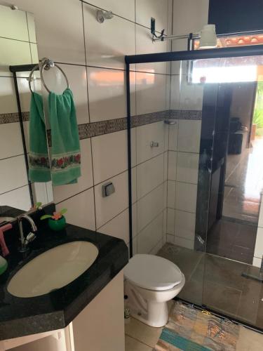 La salle de bains est pourvue de toilettes, d'un lavabo et d'une douche. dans l'établissement Rancho próximo ao lago de furnas, à Boa Esperança