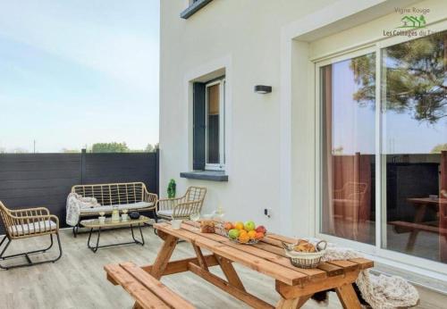 une terrasse avec une table en bois et des fruits. dans l'établissement Le Cottage Nature Vigne Rouge Clim Gaillac entre Albi-Toulouse & Les Cottages du Tarn, à Brens