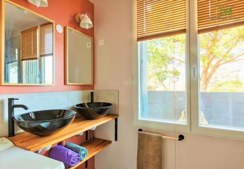 une salle de bain avec deux lavabos et deux fenêtres dans l'établissement Le Cottage Nature Vigne Rouge Clim Gaillac entre Albi-Toulouse & Les Cottages du Tarn, à Brens