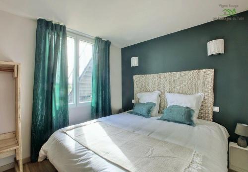 une chambre avec un grand lit aux murs verts dans l'établissement Le Cottage Nature Vigne Rouge Clim Gaillac entre Albi-Toulouse & Les Cottages du Tarn, à Brens
