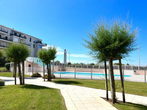 Trois arbres dans un parc à côté d'une piscine dans l'établissement Appartement 