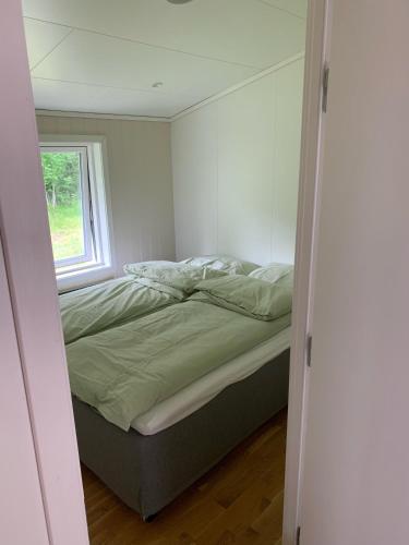 a bedroom with a bed in a room with a window at Sivert´s kontorhotell in Tomrefjord
