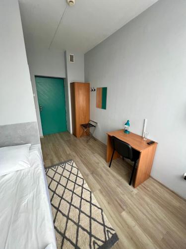 a bedroom with a desk and a room with a bed at Hotel Akor in Bydgoszcz