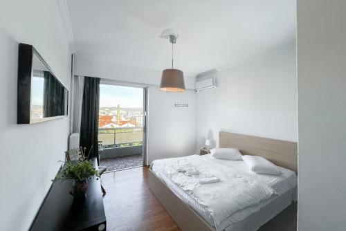 a bedroom with a bed and a large window at Urban Apartment in the Heart of Athens in Athens