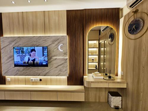 a bathroom with a television on a wall at Nagoya Thamrin City Apartment Tower A in Nagoya