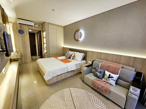 a hotel room with a bed and a couch at Nagoya Thamrin City Apartment Tower A in Nagoya
