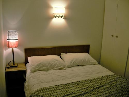- une chambre avec un lit éclairé au mur dans l'établissement Appartement Le Palais, 2 pièces, 3 personnes - FR-1-418-230, au Palais