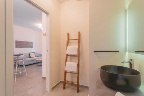 a bathroom with a black bowl sink and a living room at Enchanted Como Lake - City Apartment by Rent All Como in Como