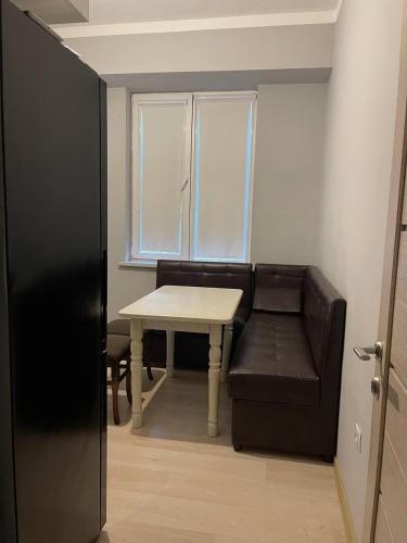 ein schwarzes Sofa und einen Tisch in einem Zimmer in der Unterkunft 3х комнатная квартира in Taschkent
