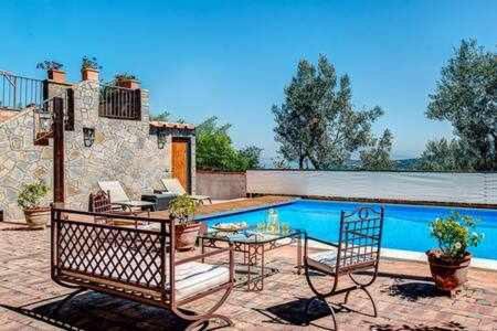 patio ze stołem i krzesłami przy basenie w obiekcie GOCCE VILLAS - Antica Limonaia w mieście Massa Lubrense