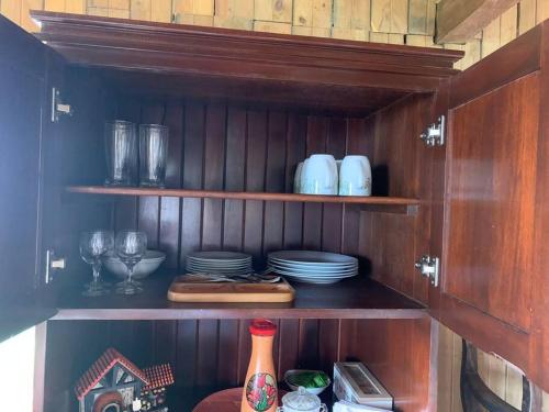 a wooden cabinet with plates and glasses and dishes at Cabaña Rancho Don Marino in Cartago