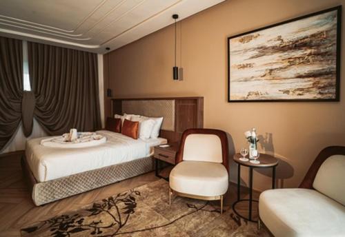ケニトラにあるCity Hotel by Wavesのベッドと椅子付きのホテルルーム