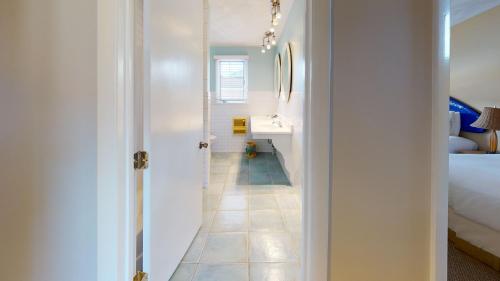 a white bathroom with a sink and a bed at Breezeway Boutique Hotel in Westerly