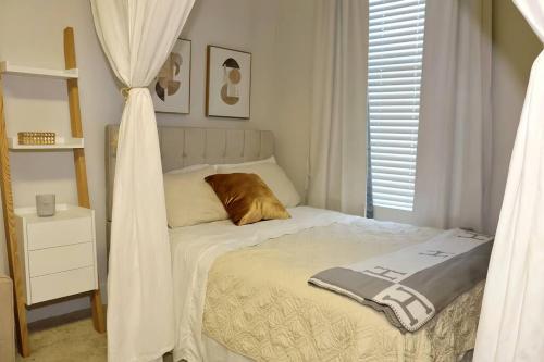 a small bedroom with a bed with a curtain at MDR Studio Apartment Luxury pool, gym, parking, jacuzzi. in Los Angeles