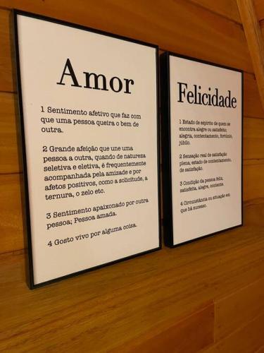 two signs on a wooden wall with a menu at Laventure Rouge- sofisticação na Serra Gaúcha in São Francisco de Paula
