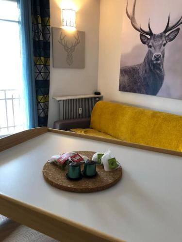 une table avec une assiette avec des tasses en haut dans l'établissement Bienvenue chez Celia et Nicolas, à Saint-Étienne-de-Tinée