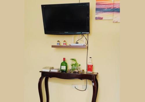 a tv on a wall with a table with a television at Paraíso Costero en Alquiler in Playas