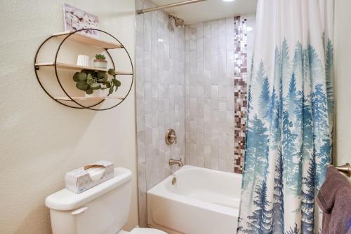 y baño con aseo y cortina de ducha. en Updated Springs Home - 3 Mi to Garden of the Gods!, en Colorado Springs