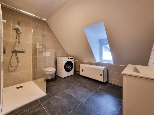a bathroom with a shower and a washing machine at Travel Homes - Rapp, charm in the heart of Colmar in Colmar
