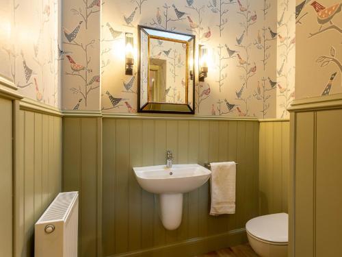 W łazience znajduje się umywalka, toaleta i lustro. w obiekcie 1 Bed in Forres 78430 w mieście Forres