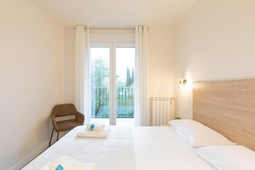 Un dormitorio con una cama y una silla y una ventana. en Enparan - baskeyrentals, en Azpeitia