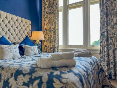 a blue bedroom with a bed with towels on it at Geltsdale East Wing in Carlisle