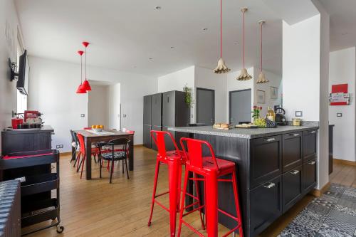 une cuisine avec tabourets de bar rouge et table dans l'établissement MAISON STELLA, à Villeurbanne