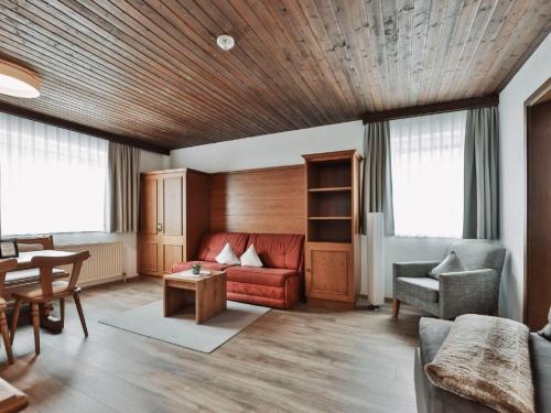 ein Wohnzimmer mit einem roten Sofa und einem Tisch in der Unterkunft Apartment Chalet Sofie-2 by Interhome in Ischgl