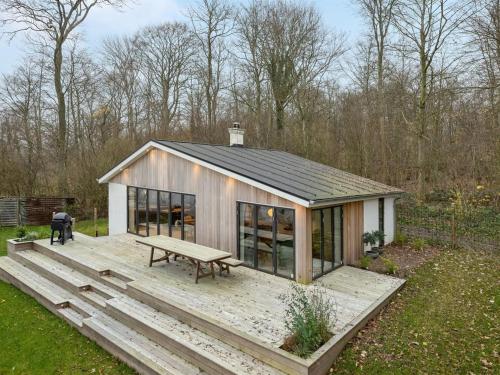 a small cabin with a picnic table on a deck at Holiday Home Lika - 25m to the inlet in SE Jutland by Interhome in Nordborg