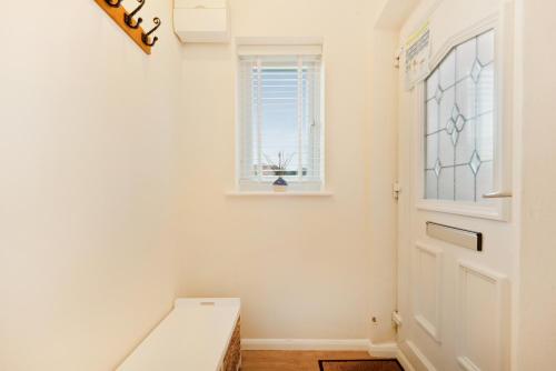 un pasillo con una puerta blanca y una ventana en Stylish short-term let in Bucks en Loudwater