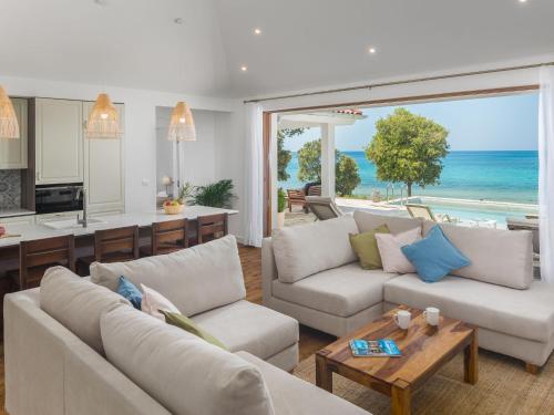 a living room with white furniture and a view of the ocean at Holiday Home Mon Perin by Interhome in Bale