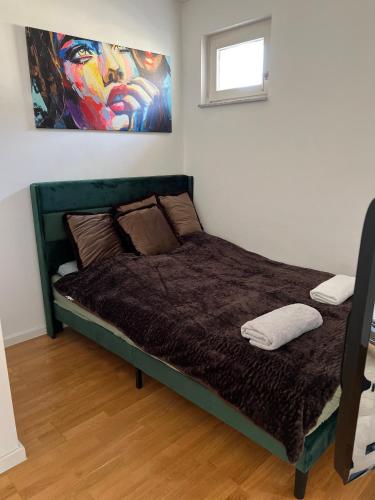 a bed in a bedroom with a painting on the wall at Kölner City Stillvolle Apartment in Cologne