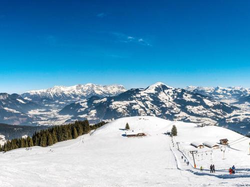 a snow covered mountain with people on a ski slope at Apartment Zauberwinkel-1 by Interhome in Esbaum