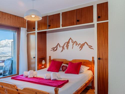 a bedroom with a large bed with red pillows at Apartment Aiglon J2 by Interhome in Nendaz