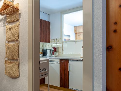 a kitchen with white cabinets and a window at Apartment Aiglon J2 by Interhome in Nendaz