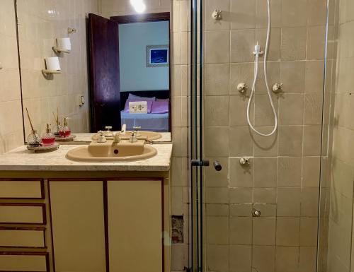 a bathroom with a sink and a shower at Guaru Surf Hostel in Guarujá