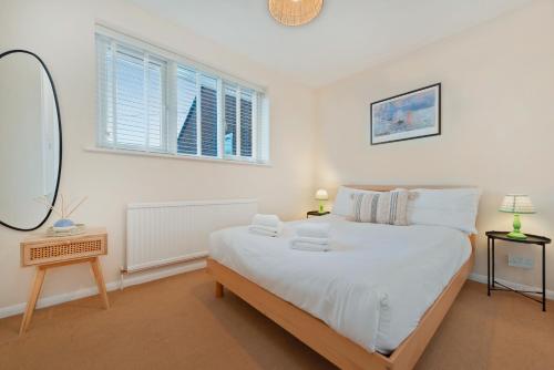 Un dormitorio con una gran cama blanca y una ventana en Stylish short-term let in Bucks en Loudwater